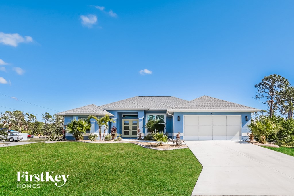 a blue house with a garage and a lawn