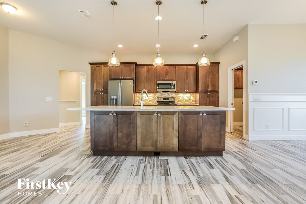 an open kitchen and living room with wooden cabinets