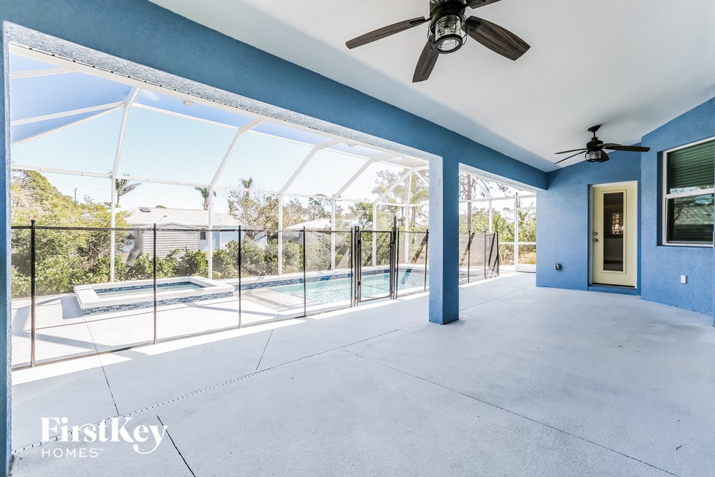 a large patio with a pool and a ceiling fan