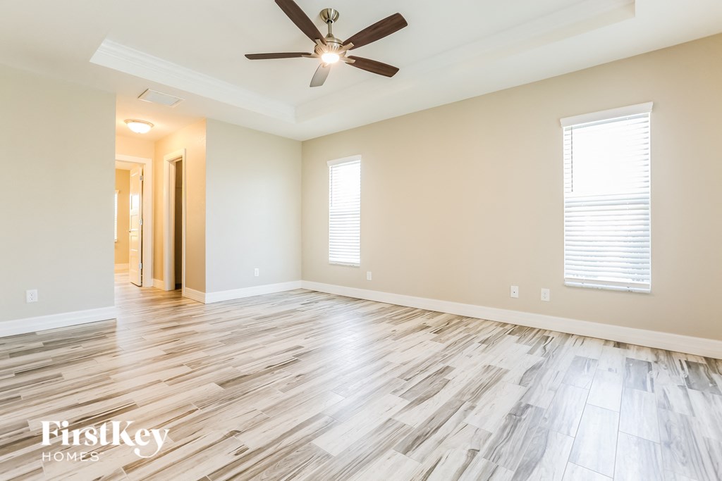 the living room with wood floors and a ceiling fan