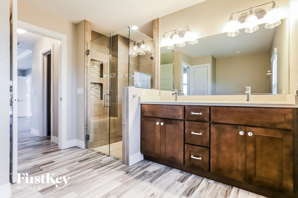 a bathroom with a large mirror and wooden cabinets
