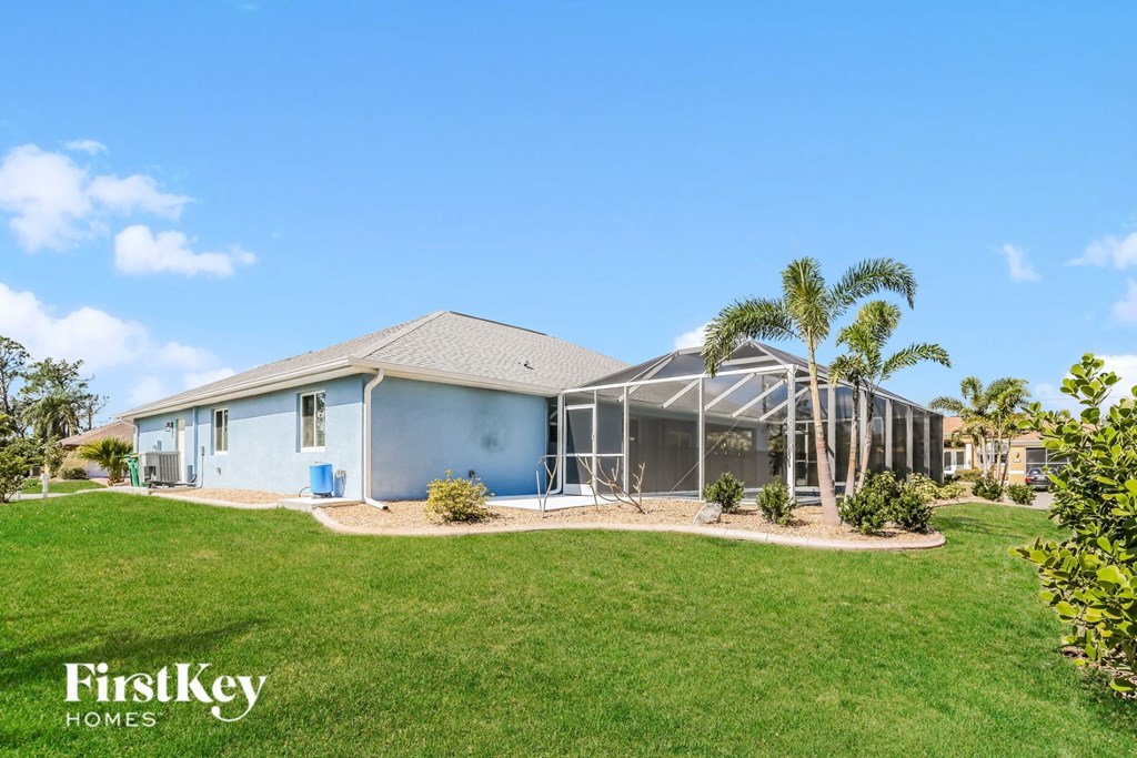 a house with a lawn and palm trees in front of it