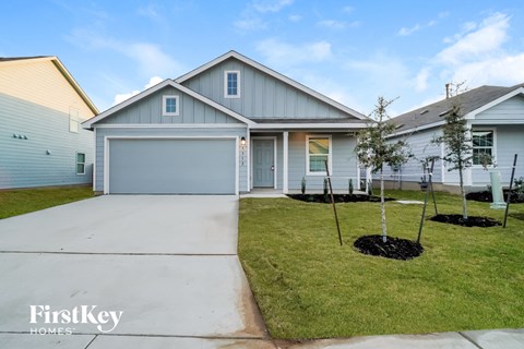 a blue house with a sidewalk and lawn in front of it