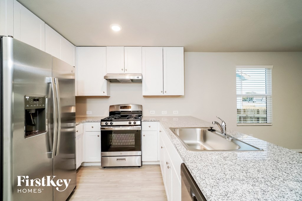a kitchen with white cabinets and stainless steel appliances