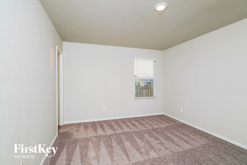 a spacious living room with carpet and a window