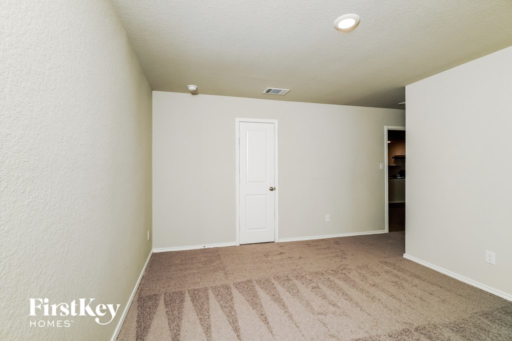 a bedroom with a white door and a carpeted floor