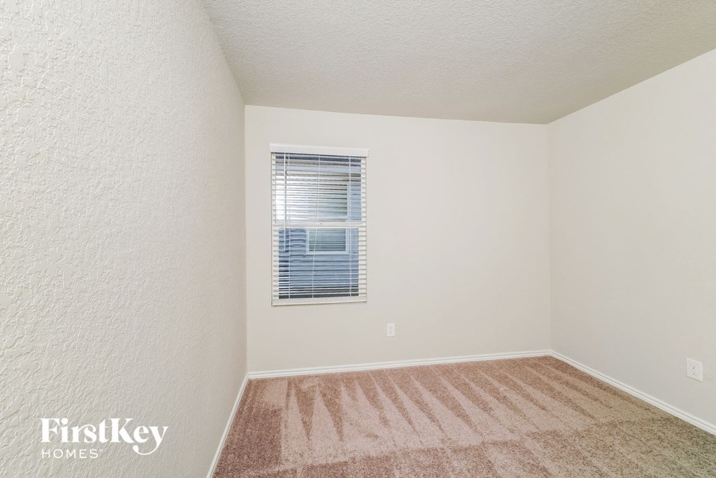 a spacious room with carpet and a window
