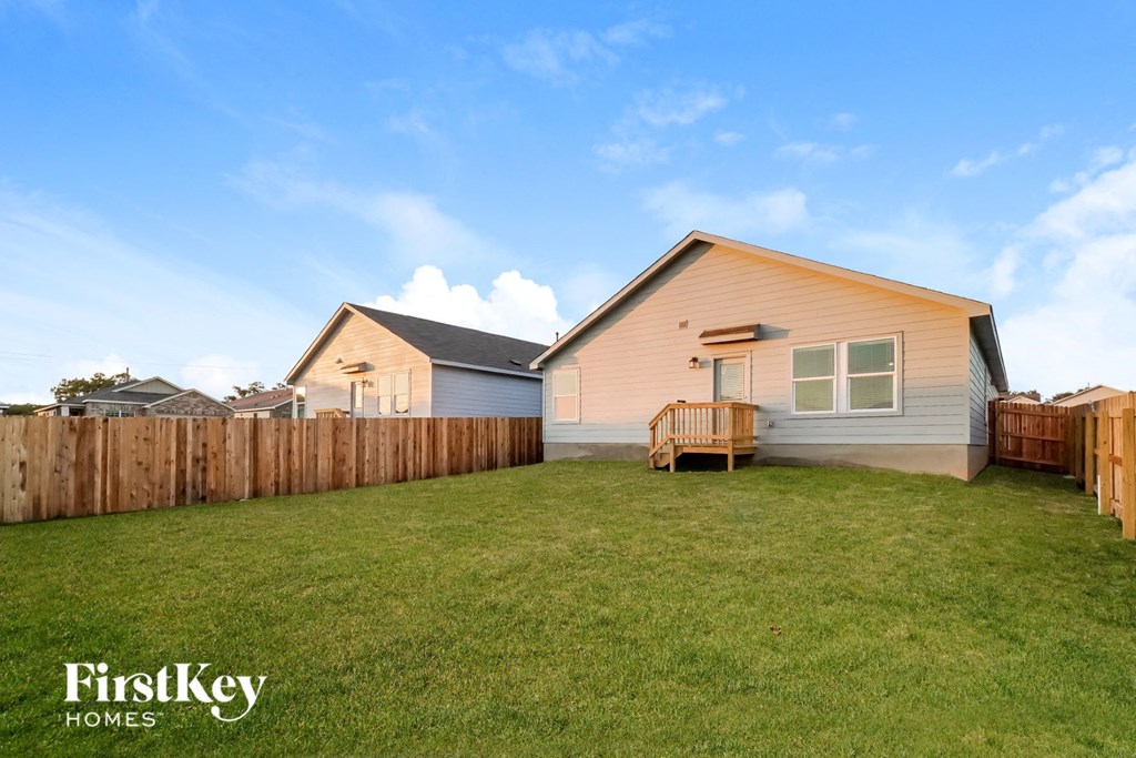 a backyard with a wooden fence and a house