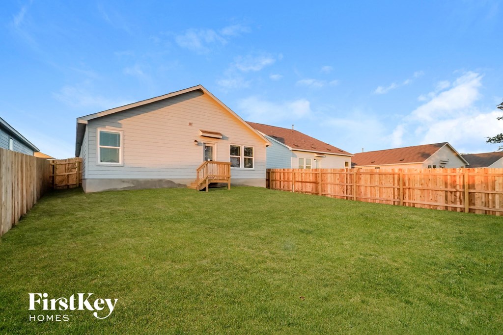 a backyard with a fence and a house