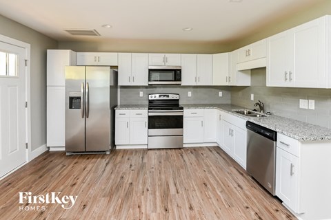 a kitchen with white cabinets and stainless steel appliances