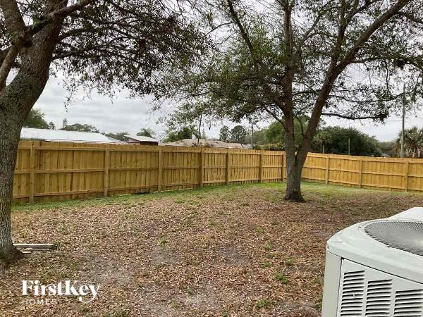 a backyard with a wooden fence and trees