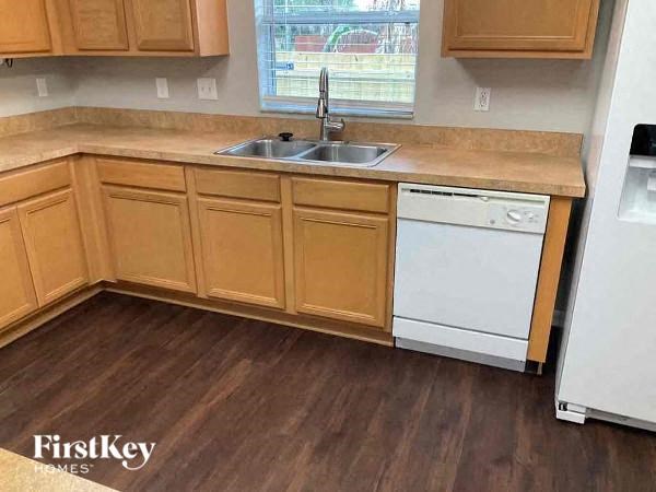 a kitchen with wooden cabinets and a sink and a dishwasher