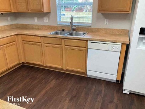 a kitchen with wooden cabinets and a sink and a dishwasher
