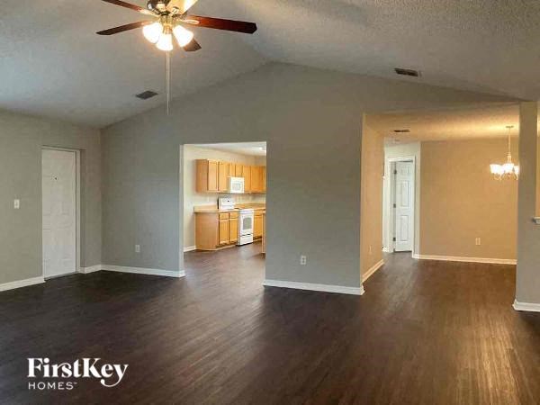 an empty living room with a ceiling fan