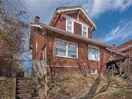 a red brick house on the side of a hill