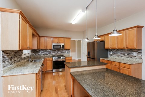 A kitchen with wooden cabinets and granite countertops.