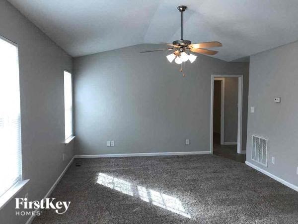 A room with a ceiling fan and a door.