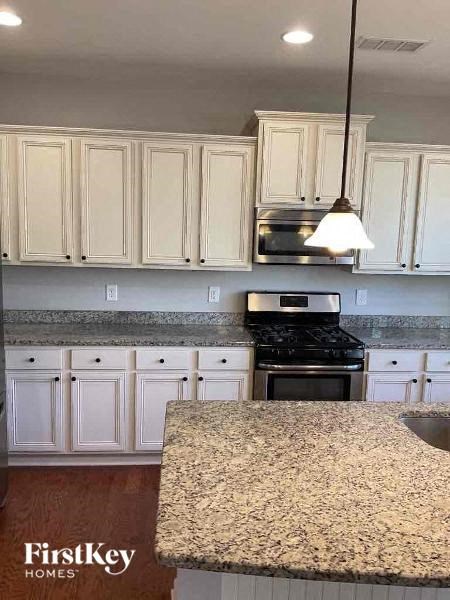 a kitchen with white cabinets and a granite counter top