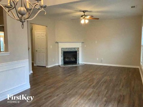 a living room with a fireplace and a ceiling fan