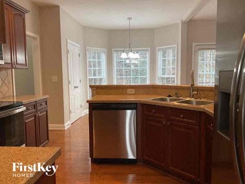 A kitchen with wooden cabinets and a stainless steel dishwasher.