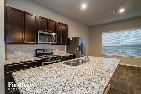 a kitchen with granite counter tops and stainless steel appliances