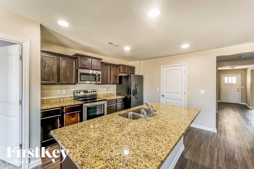 A kitchen with granite countertops and a refrigerator.