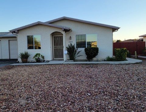 A house with a gravel driveway in front.