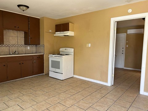 an empty kitchen with a stove and a refrigerator