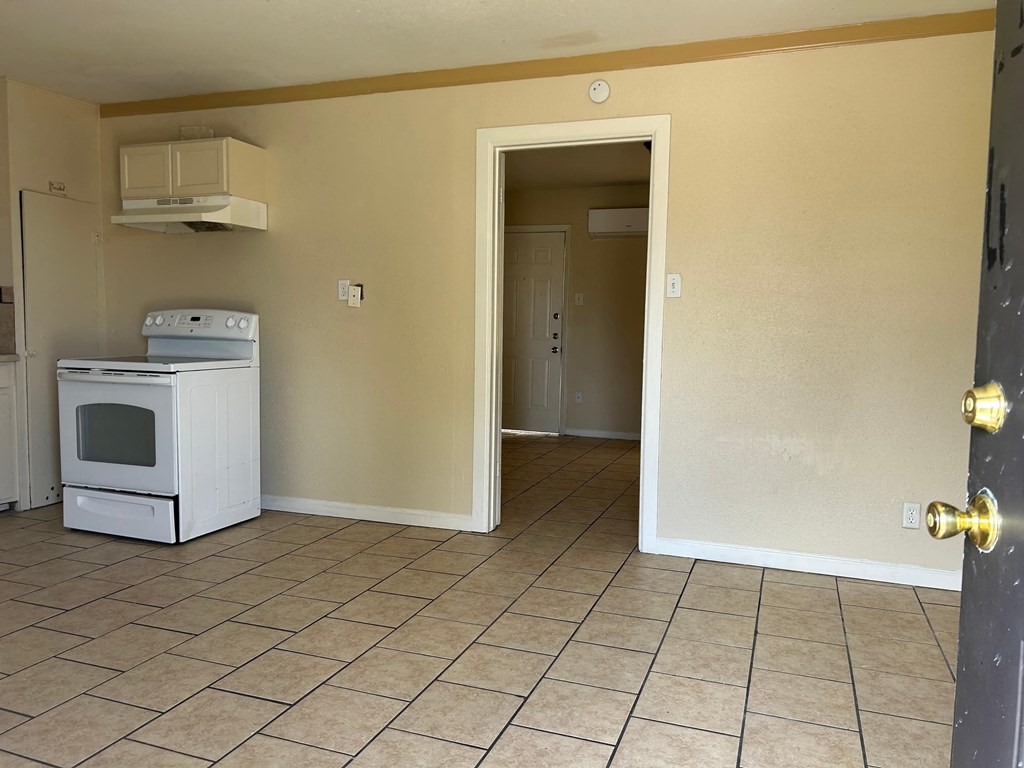 an empty kitchen with a stove and a refrigerator