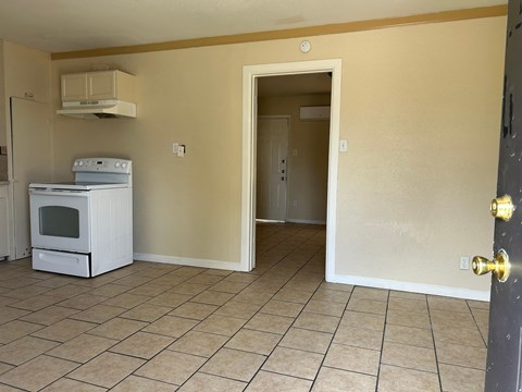 an empty kitchen with a stove and a refrigerator