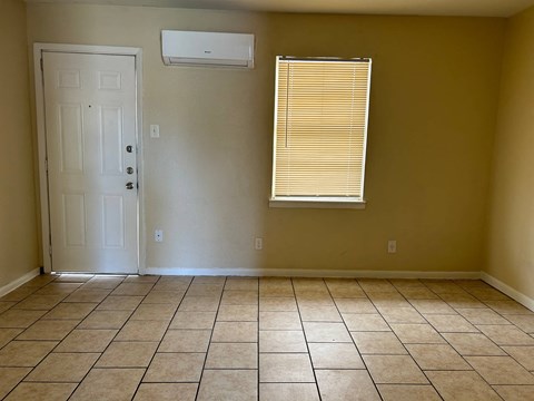 a room with a tiled floor and a window and a door