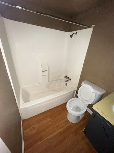 a bathroom with a toilet and a tub and a sink
