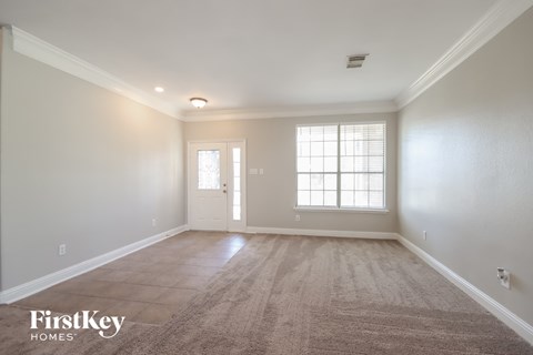 the living room of a new home with white walls and carpet
