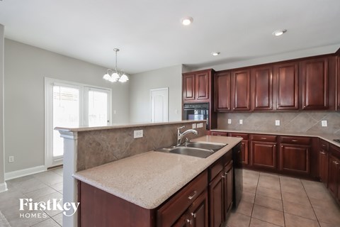 a kitchen with wood cabinets and an island with a sink