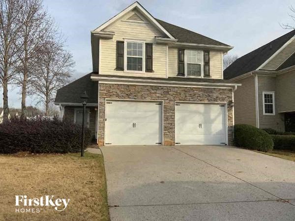 A two-car garage is attached to a house with a stone facade.