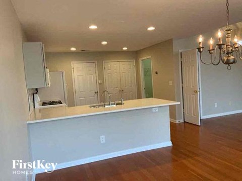 A kitchen with a white countertop and a chandelier hanging from the ceiling.