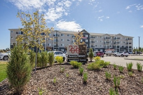 A sign in front of a building reads 460 West Twenty Apartment Homes.