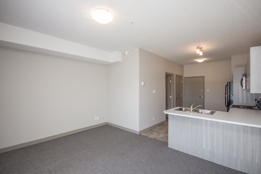 A large, empty room with a sink and mirror.