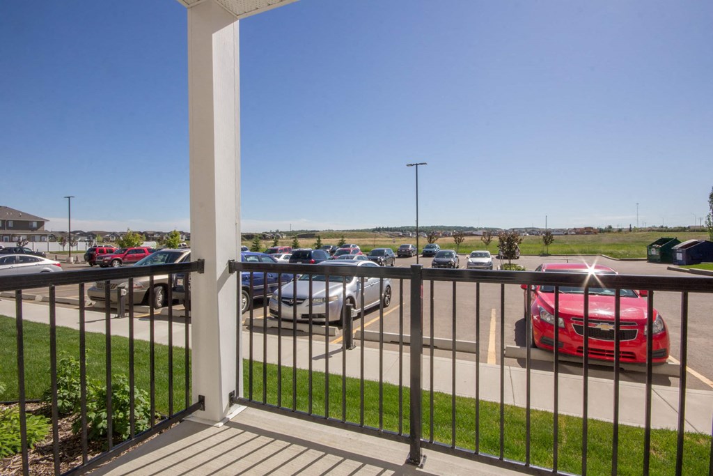 A parking lot with cars and a red car in the foreground.