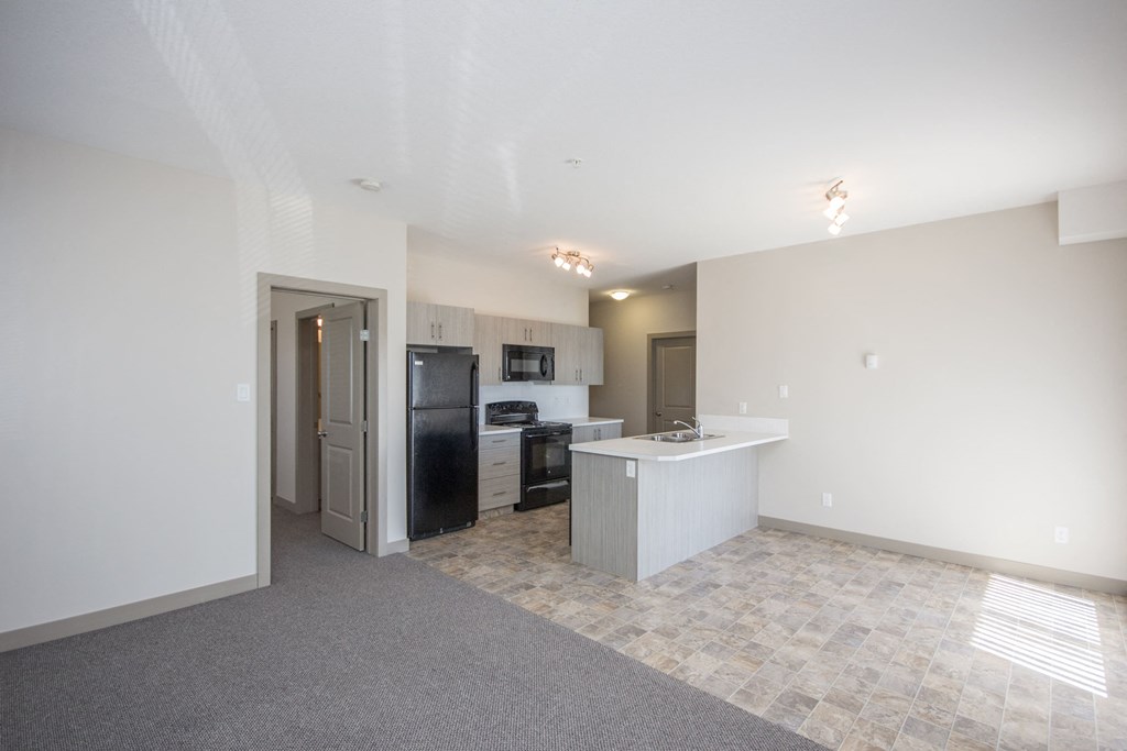 A kitchen area with a refrigerator, microwave, and oven.