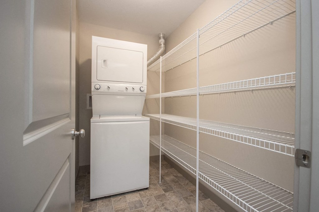 A white refrigerator is in a room with a door open.