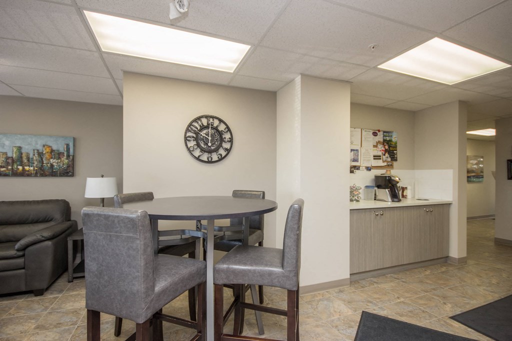 A conference room with a clock on the wall and a couch.