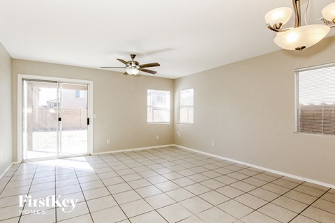 A spacious room with a ceiling fan and tiled flooring.