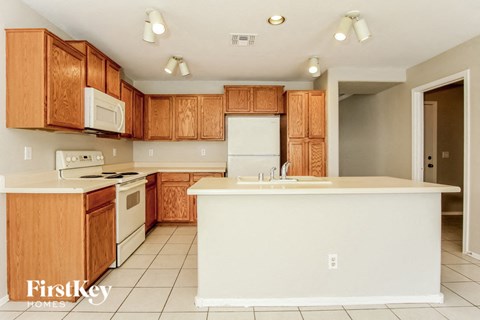 A kitchen with wooden cabinets and white appliances.
