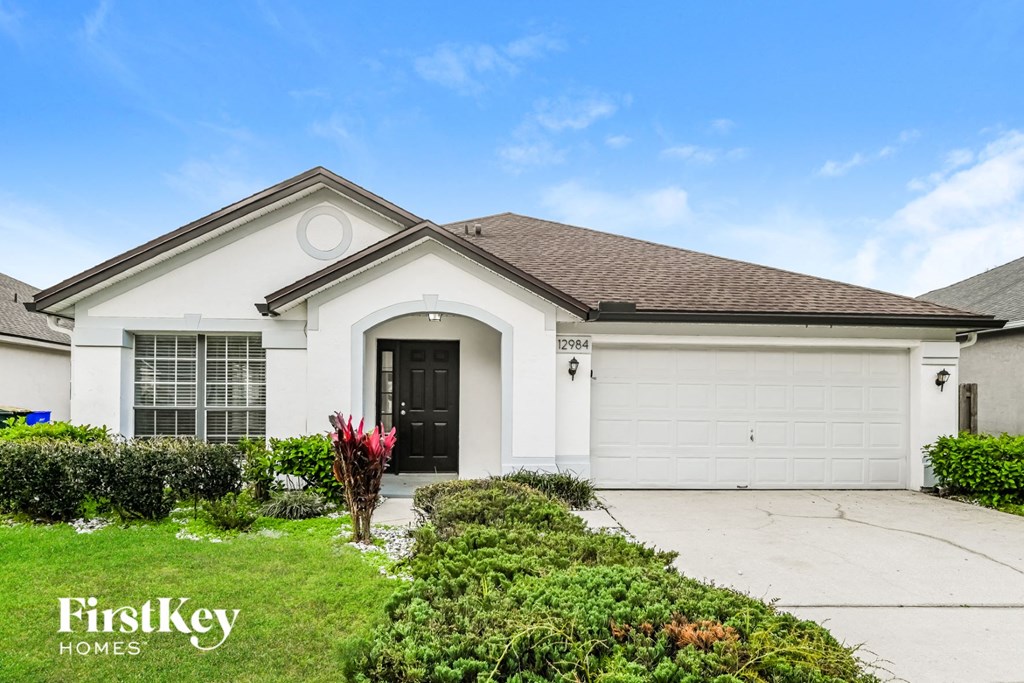 a white house with a driveway and a garage door