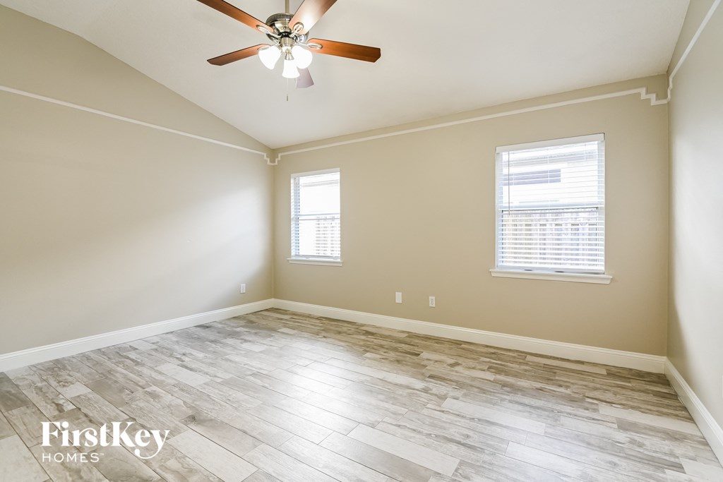 a living room with wood floors and a ceiling fan
