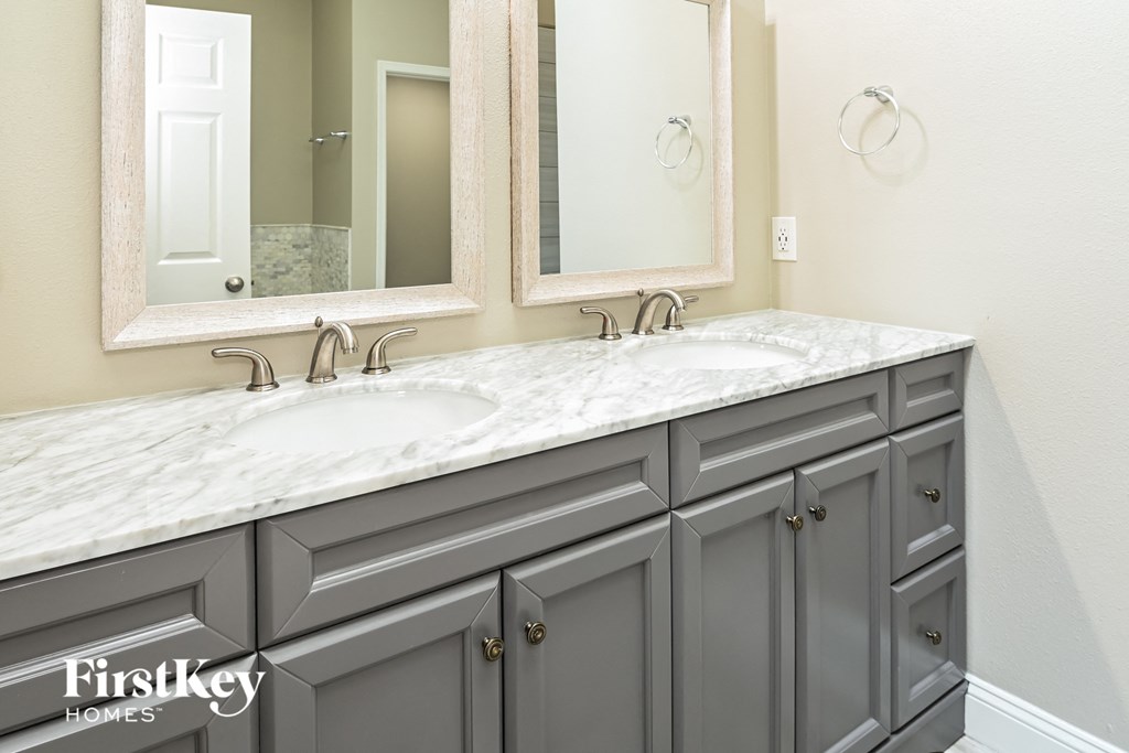 a bathroom with two sinks and two mirrors