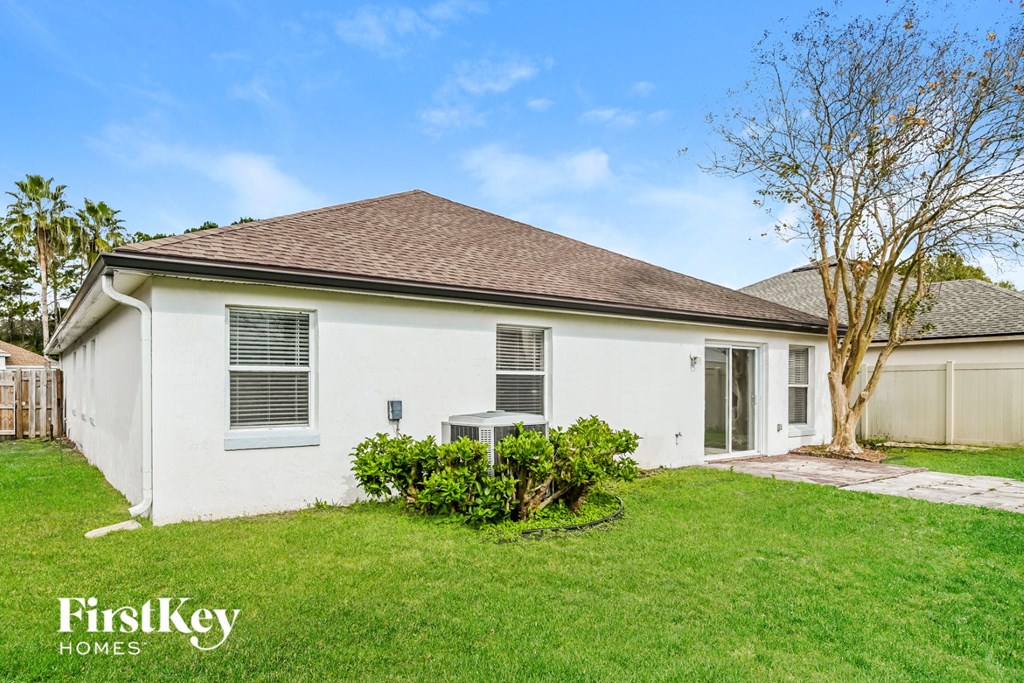 a white house with a grassy yard and a patio