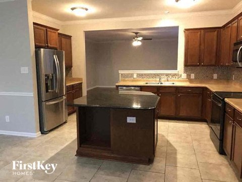 A kitchen with a black counter top and wooden cabinets.