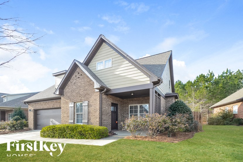 A house with a grey roof and a sign that says "Firstkey" in front of it.